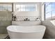 Modern bathroom with a large soaking tub and glass shower at 14866 W Windsor Ave, Goodyear, AZ 85395