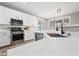 Modern kitchen with white cabinets, quartz countertops, and a large sink at 14866 W Windsor Ave, Goodyear, AZ 85395