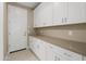 Laundry room with white cabinets, countertop, and built-in storage at 16936 W Sheridan St, Goodyear, AZ 85395