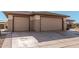 Two-car garage with tan doors and driveway at 16983 W Desert Blossom Way, Surprise, AZ 85387