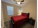 Bright bedroom with a red bedspread and ceiling fan at 17429 W Country Club Ter, Surprise, AZ 85387