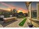 Evening view of patio with fire pit, putting green, and landscaping at 17531 W Liberty Ln, Goodyear, AZ 85338