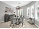 Bright dining room with glass table, four chairs, and a modern chandelier at 17531 W Liberty Ln, Goodyear, AZ 85338