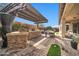 Outdoor kitchen and dining area with pergola at 17531 W Liberty Ln, Goodyear, AZ 85338