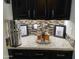 Wet bar with granite countertop, dark cabinetry, and decorative accents at 17531 W Liberty Ln, Goodyear, AZ 85338