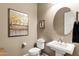 Elegant powder room featuring a pedestal sink, decorative mirror and artwork at 1783 E Desert Broom Pl, Chandler, AZ 85286