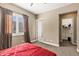 Bright bedroom features a red bedspread, window with shutters, and neutral colored walls at 1783 E Desert Broom Pl, Chandler, AZ 85286