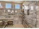 An expansive glass-enclosed shower with beautiful tile work and a shower bench at 1783 E Desert Broom Pl, Chandler, AZ 85286