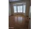 Comfortable bedroom featuring a bright bay window, light walls, and attractive wood floors at 20301 N Queen Palm Ln, Surprise, AZ 85374