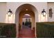 Arched entryway with illuminated lanterns and lush greenery at 20606 W Daniel Pl, Buckeye, AZ 85396