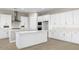 Modern kitchen with white cabinets, quartz countertops, and a large island at 2320 W Moody Trl, Phoenix, AZ 85041