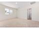 Well-lit bedroom with carpet flooring and an ensuite bathroom at 25838 W Samantha Way, Buckeye, AZ 85326