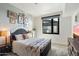 Well-lit bedroom with a queen bed, dresser with a TV, and a view of the city at 310 S 4Th St # 908, Phoenix, AZ 85004