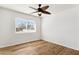 Bright bedroom with wood floors, ceiling fan, and large window at 3312 E Flower St, Phoenix, AZ 85018