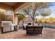 Relaxing backyard patio with built-in fireplace, grill, and seating area at 41007 N Harbour Town Way, Anthem, AZ 85086