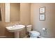 Clean and simple bathroom with white pedestal sink, toilet and framed art at 41007 N Harbour Town Way, Anthem, AZ 85086