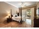 Bright bedroom with a four-poster bed, hardwood floors, and patio access at 41007 N Harbour Town Way, Anthem, AZ 85086