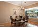 Bright dining room features a glass-top table, chandelier, and hardwood floors at 41007 N Harbour Town Way, Anthem, AZ 85086