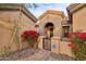 Elegant entryway with arched doorway, lush landscaping, and security gate at 41007 N Harbour Town Way, Anthem, AZ 85086