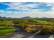 Scenic view of a lush green golf course with trees and distant mountains at 41007 N Harbour Town Way, Anthem, AZ 85086