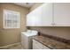 Laundry room with washer, dryer, and ample cabinets at 41007 N Harbour Town Way, Anthem, AZ 85086