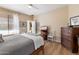 Comfortable bedroom with a wood dresser, TV, and soft bedding at 42949 N Voyage Trl, Phoenix, AZ 85086