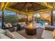Evening view of covered patio with fire pit and seating at 4516 E Madre Del Oro Dr, Cave Creek, AZ 85331