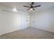 Well-lit bedroom with ceiling fan and carpet flooring, with hallway access at 4720 E Belleview St, Phoenix, AZ 85008