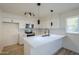 Modern white kitchen with stainless steel appliances and an island at 4720 E Belleview St, Phoenix, AZ 85008