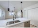Open concept kitchen boasts white cabinets, a large island, and stainless steel sink at 4720 E Belleview St, Phoenix, AZ 85008