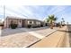 Tan single-story home with carport and palm tree in front at 5241 E Lindstrom Ln, Mesa, AZ 85215