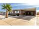 Tan single-story home with carport and palm tree in front at 5241 E Lindstrom Ln, Mesa, AZ 85215