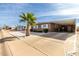 Tan single-story home with carport and palm tree in front at 5241 E Lindstrom Ln, Mesa, AZ 85215