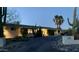 Brightly lit home exterior at dusk with desert landscaping at 7760 E Carefree Dr, Carefree, AZ 85377