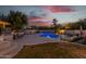Inviting kidney-shaped pool with outdoor entertaining area at sunset at 7760 E Carefree Dr, Carefree, AZ 85377