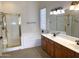 Bathroom featuring a bathtub, shower with gold trim, and double sink vanity with cabinets at 8014 E Plata Ave, Mesa, AZ 85212