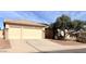 Home exterior featuring a tan garage door, desert landscaping, and a tiled roof at 8014 E Plata Ave, Mesa, AZ 85212