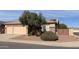 Two car garage and front yard landscaping with a large tree and gate at 8014 E Plata Ave, Mesa, AZ 85212