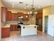 Well-lit kitchen with stainless steel appliances, a center island, tile backsplash, and wood cabinets at 8014 E Plata Ave, Mesa, AZ 85212