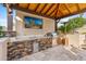 Outdoor kitchen with built-in grill, TV, and stone countertops at 8040 E Laurel St, Mesa, AZ 85207