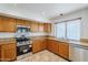 Kitchen with wood cabinets, granite counters, and stainless steel appliances at 16649 W Polk St, Goodyear, AZ 85338