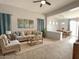 Inviting living room with neutral tones, ceiling fan, natural light, and an open concept floor plan at 17545 W Canyon Ln, Goodyear, AZ 85338
