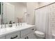 Bright bathroom featuring white cabinets, subway tile, a large mirror and a shower curtain at 25516 S 205Th Way, Queen Creek, AZ 85142