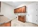 Laundry room with wood cabinets and granite countertops at 38724 N Donovan Ln, Anthem, AZ 85086