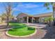 Landscaped backyard with artificial turf and a covered patio at 5026 W Parsons Rd, Phoenix, AZ 85083