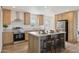 Well-equipped kitchen featuring wooden cabinetry, stainless steel appliances, and a center island with seating at 53212 W Barn Owl Rd, Maricopa, AZ 85139