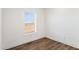 Small bedroom with window and wood floor at 53259 W Barn Owl Rd, Maricopa, AZ 85139