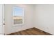 Simple bedroom with large window and wood floor at 53259 W Barn Owl Rd, Maricopa, AZ 85139