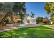 Landscaped backyard with a charming pergola and grassy lawn at 6340 E Huntress Dr, Paradise Valley, AZ 85253