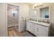 Elegant bathroom with a double vanity, marble shower, and wood-look floors at 6542 E Ludlow Dr, Scottsdale, AZ 85254